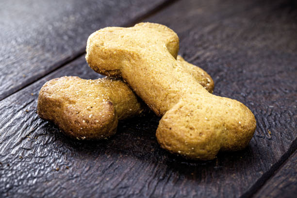 istock bone shaped dog biscuit with wooden background, copy space 1332029684