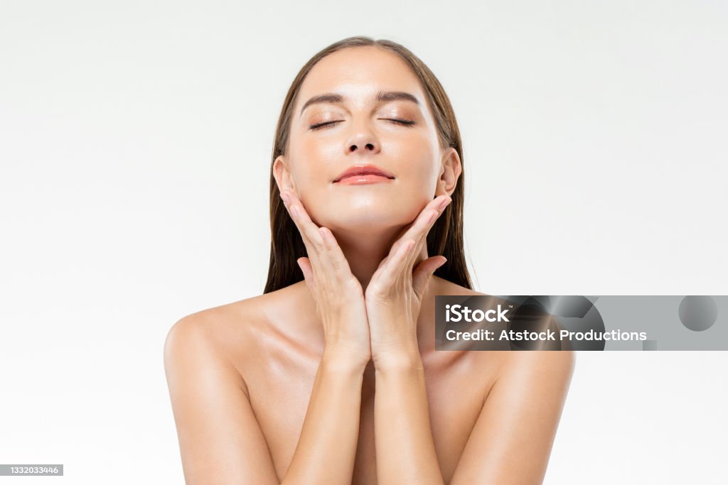 Beautiful Caucasian woman with clean glowing face skin in isolated studio white background for beauty and skin care concepts Skin Stock Photo