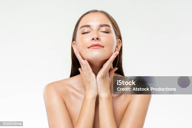 Beautiful Caucasian Woman With Clean Glowing Face Skin In Isolated Studio White Background For Beauty And Skin Care Concepts Stock Photo - Download Image Now