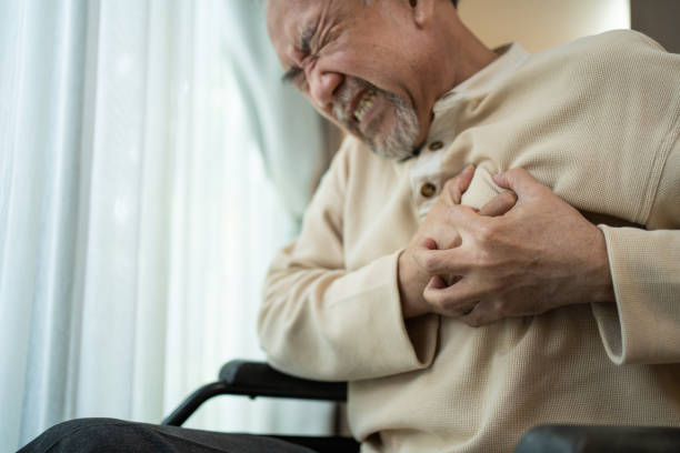 가슴 통증을 가진 아시아 수석 장애인 남성은 심장 마비로 고통받고 있습니다. 휠체어를 탄 노인 남성은 급성 통증으로 가슴을 움켜쥐는 데 어려움을 겪고 있습니다. 병원 의료 및 의료 개념 - pulse trace human cardiovascular system heart shape heart disease 뉴스 사진 이미지