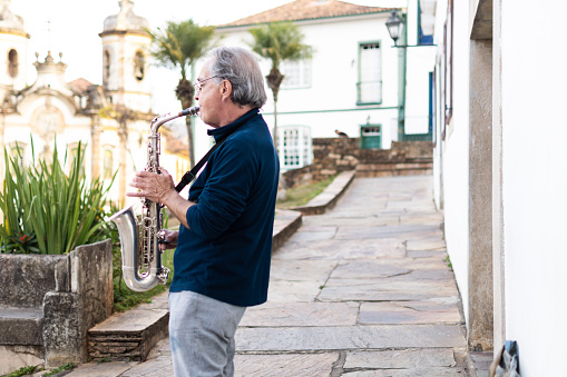 Portrait of a musician playing the saxophone in a historic city