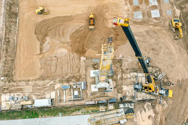 istock installing tower crane. aerial view of construction site during earthworks in progress. flattening ground on construction site by construction heavy machinery. 1332052991