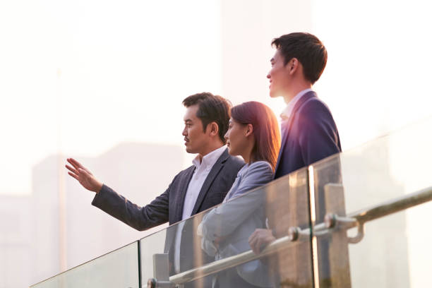 istock asian corporate executives standing on rooftop discussing business 1332054968