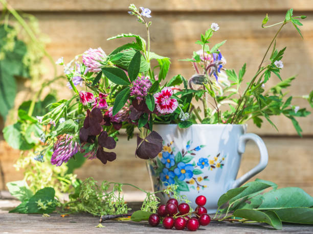 istock Summer small bouquet in a mug with floral decor on a stool on the veranda 1332059794