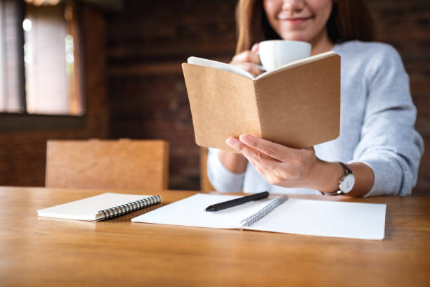 istock a beautiful woman reading a book while drinking coffee in the morning 1332062363