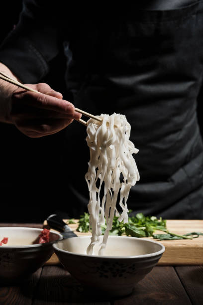 istock Chef picking noodles with chopsticks 1332064486