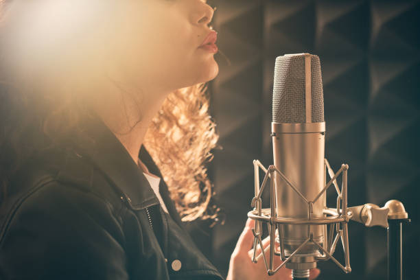 istock Pretty female singer recording in music studio 1332068669