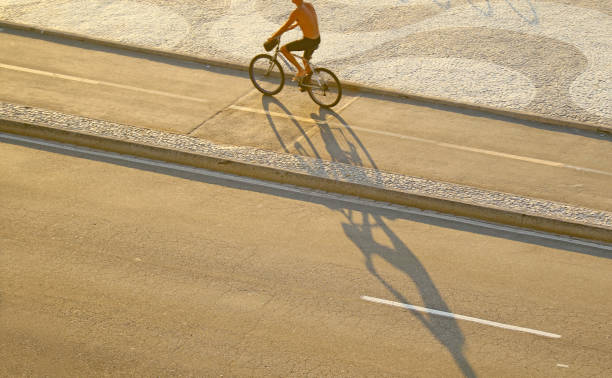 mann radelt auf dem wellenmuster bürgersteig, copacabana strand in rio de janeiro, brasilien - brazil bicycle rio de janeiro outdoors stock-fotos und bilder