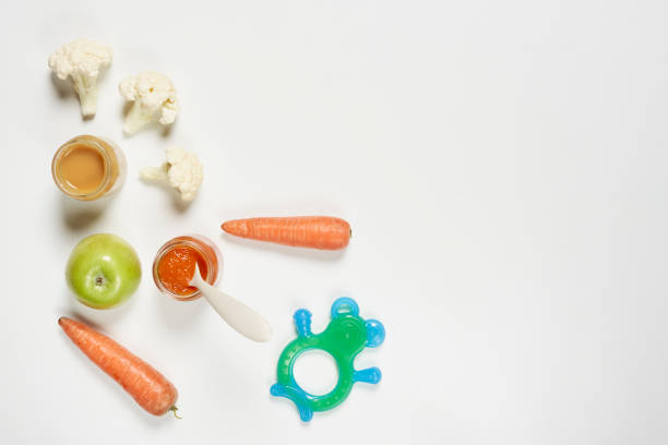 Healthy organic fruits and vegetables with puree glasses for baby. Baby food background with copy space. Organic, sugar-free baby food background on bright background