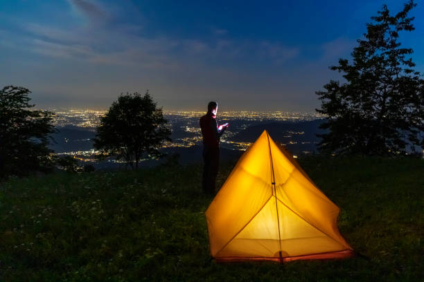 istock Hiker checking smartphone app during camping solo at night 1332071956