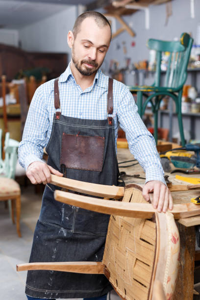 istock Carpenter repairing antique chair 1332072310