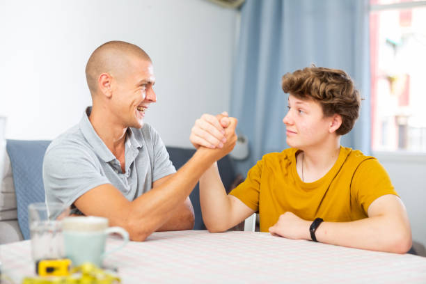 istock Son and his dad arm wrestling 1332074765