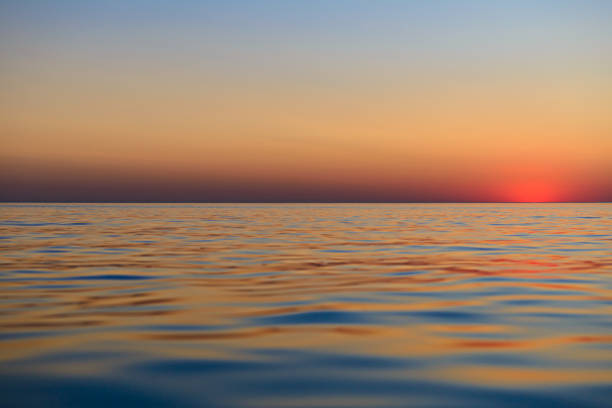 Sunset over the surface of the sea with small waves