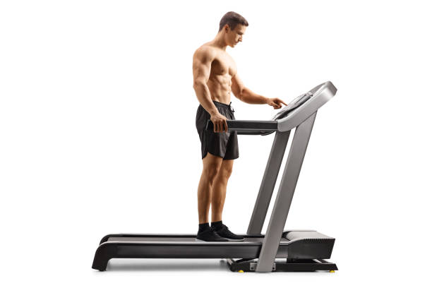 istock Full length profile shot of a shirtless young man setting a program on a treadmill 1332079123