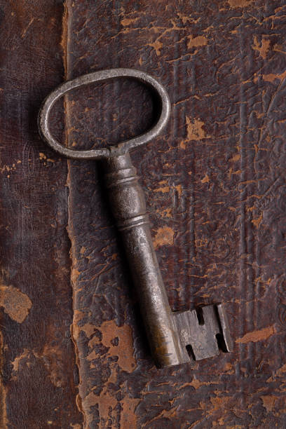 istock Door key in old metal, on an ancient brown surface. 1332081638