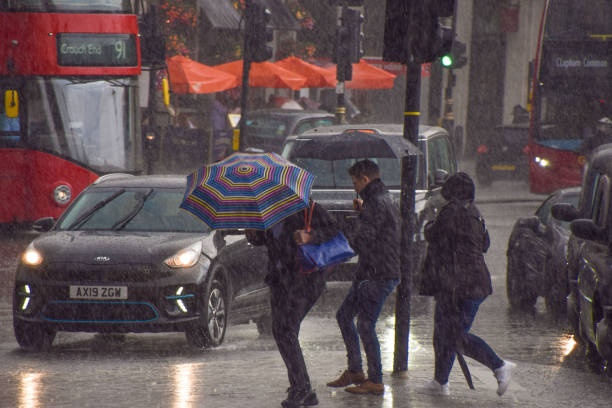 sintflutartiger regen fällt in london, großbritannien - drenched raincoat rain clothing stock-fotos und bilder