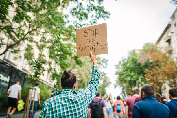 Stand for your rights! Young man with a poster in his hands. Young activist / protester against the corruption. Human rights and social issues concept. corruption stock pictures, royalty-free photos & images