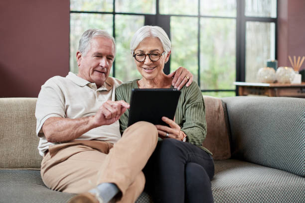 istock Shot of a senior couple using a digital tablet while relaxing on a sofa at home 1332084484