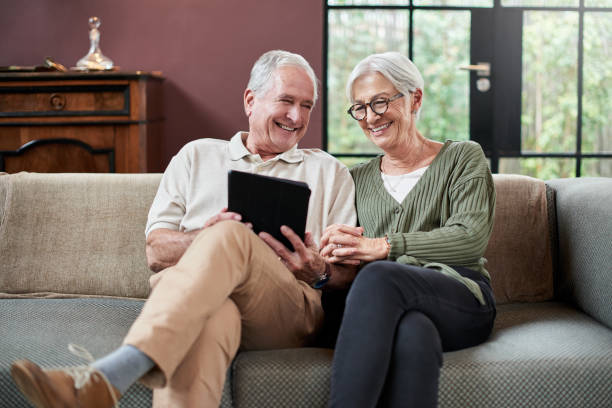 istock Shot of a senior couple using a digital tablet while relaxing on a sofa at home 1332084486