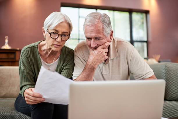 istock Shot of a senior couple using a laptop while going through paperwork at home 1332084812