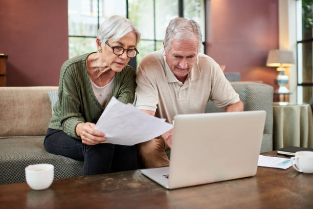 istock Shot of a senior couple using a laptop while going through paperwork at home 1332084813