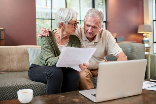 istock Shot of a senior couple using a laptop while going through paperwork at home 1332084815