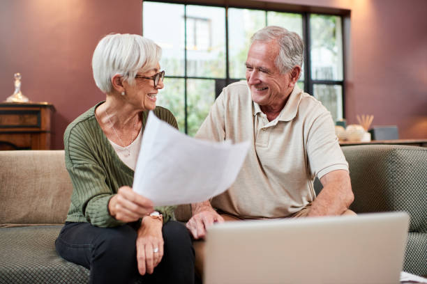 istock Shot of a senior couple using a laptop while going through paperwork at home 1332084816