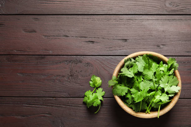 istock Fresh aromatic cilantro on wooden table, flat lay. Space for text 1332085531