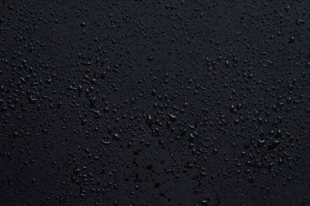 istock Water drops isolated on black glass background. Rain texture 1332085605