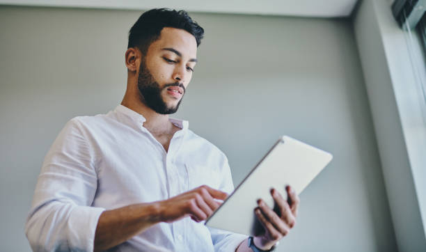 istock Shot of a young businessman using a digital tablet in a modern office 1332087158