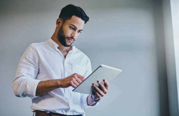 istock Shot of a young businessman using a digital tablet in a modern office 1332087160