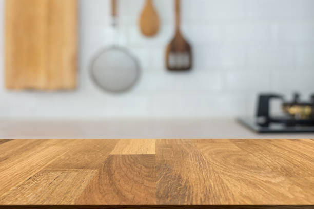 istock Empty old wooden top table in front of blurred beautiful white kitchen and kitchen equipment in Scandinavian home background. Can be used for display or montage for show your products. 1332087248