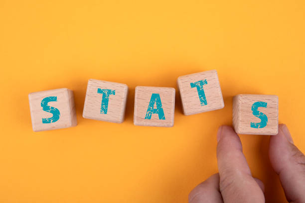 istock STATS. Wooden blocks and a man's hand on a yellow background 1332087678