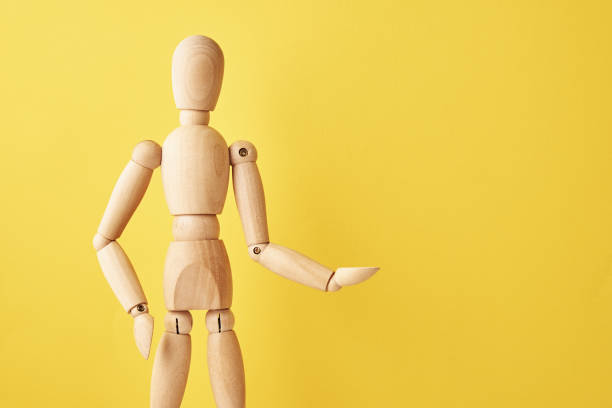 istock Wooden doll on yellow background 1332089112
