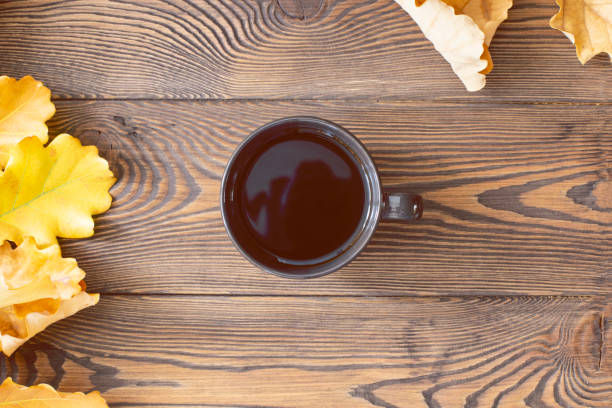 중앙에 있는 검은 커피 컵과 나무 테이블에 노란색 참나무 잎의 최고 전망. 가을 또는 겨울 구성. 복사 공간 - 2675 뉴스 사진 이미지