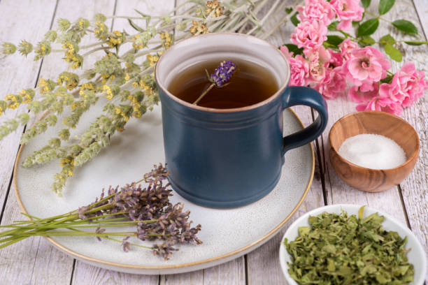 istock Green tea or herbal tea with cup, sugar and dry herbs 1332090238
