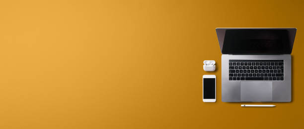 istock Flat lay top view office desk working space with laptop on orange background. Copy space. 1332092738