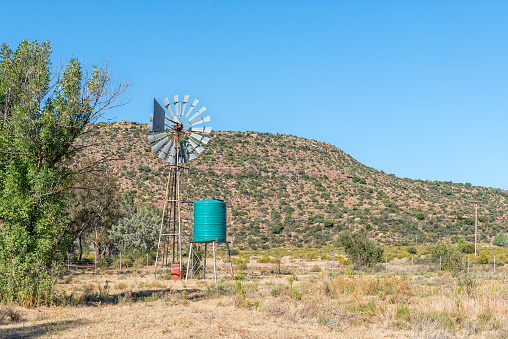 A water-pumping windmill and water tank on a farm on road D2679 in the Eastern Cape Province