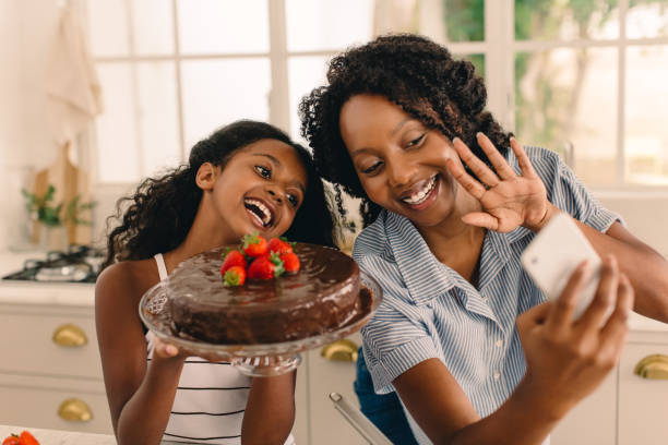 feliz familia joven con pastel tomando selfie en la cocina - cake birthday domestic kitchen child fotografías e imágenes de stock