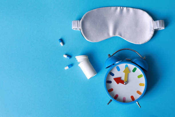 istock Sleeping mask, pills and alarm clock on light blue background, flat lay. Insomnia treatment 1332097184