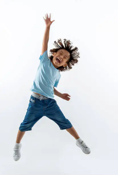 Photo of Little boy jumping on white background