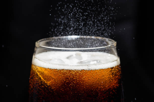 istock A glass of cola beverage with a salt. On a black background 1332099427