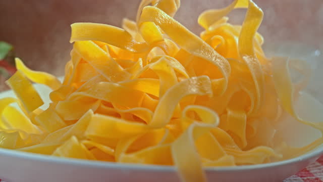 SLO MO Steaming hot pasta falling onto a plate