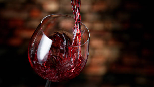 freeze motion of red wine pouring into glass. - wijn stockfoto's en -beelden