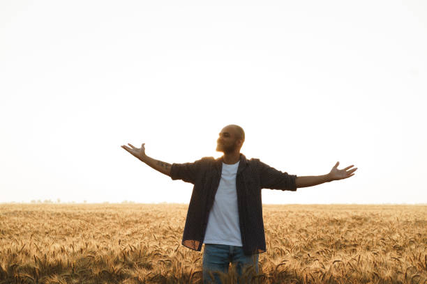 istock Young man standing in wheat field on sunset 1332102374