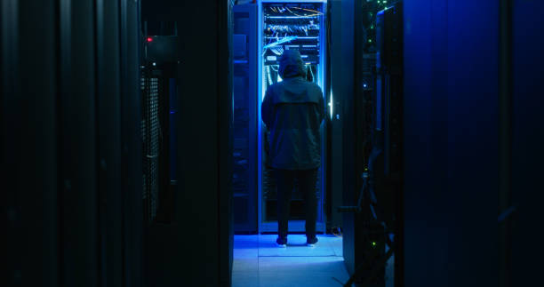 istock Shot of a hacker walking through a server room 1332104424