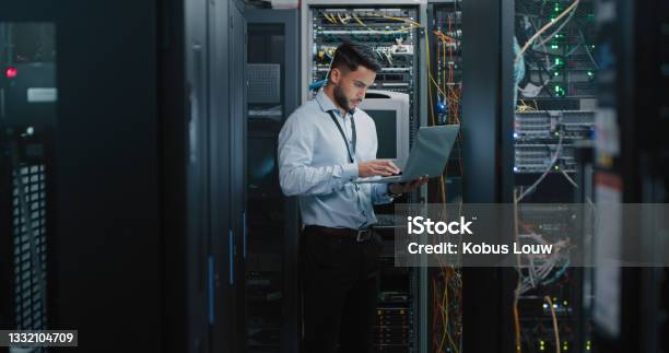 Shot Of A Young Male Engineer Using His Laptop In A Server Room Stock Photo - Download Image Now