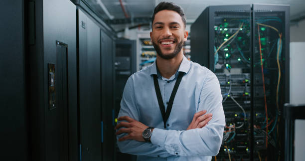 Shot of a young male engineer working in a server room I'm the expert they need data center stock pictures, royalty-free photos & images