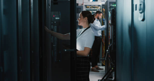 foto de dos colegas trabajando juntos en una sala de servidores - data center computer programmer women fotografías e imágenes de stock