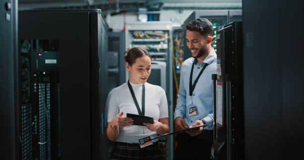 shot of two colleagues working together in a server room - data center imagens e fotografias de stock
